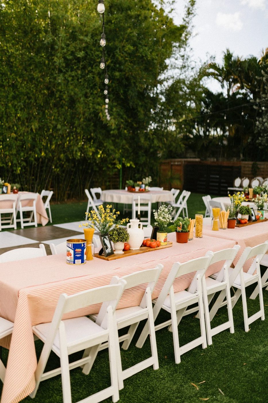 Long outdoor celebration table with blush linens on the lawn