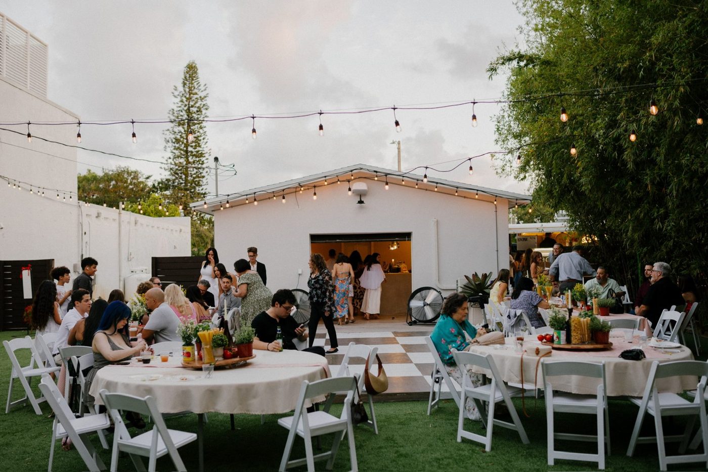 Guests gathered at round tables under string lights in the Sol Haus courtyard