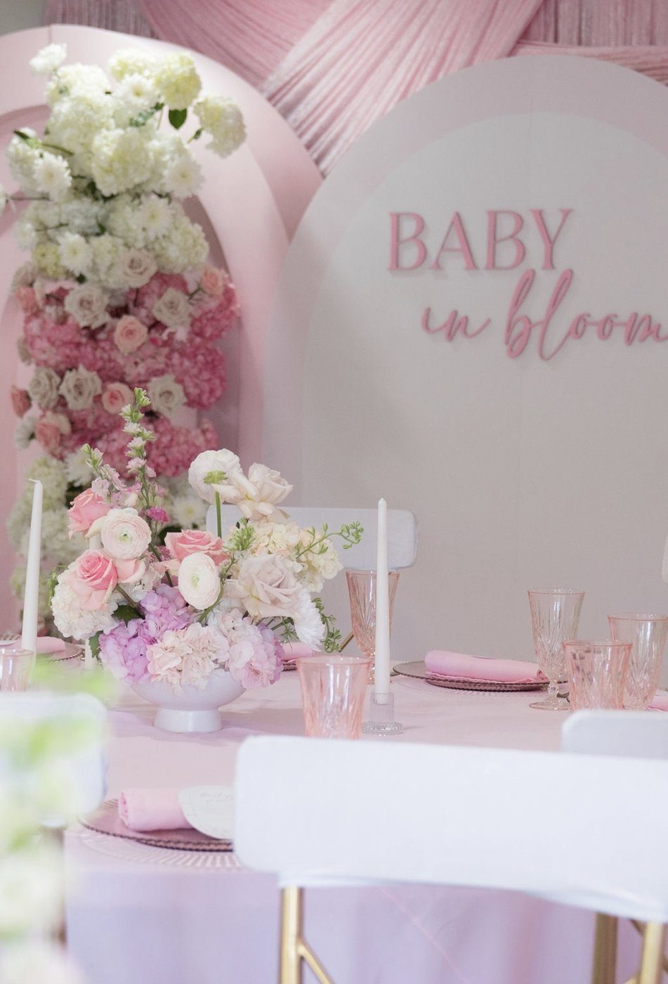 Blush 'Baby in Bloom' shower setup with florals and a draped table